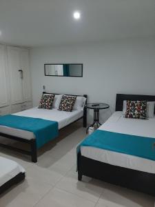 Habitación con 2 camas y mesa. en Cartagena Linda 204, en Cartagena de Indias