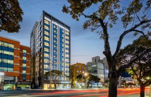 a city street with tall buildings and trees at Ventimo Hotel & Residence Jeju in Jeju
