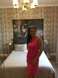 a woman in a red dress standing in front of a bed at Luxury Suite in Rimini