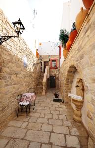 a stone walkway with a bench and a building at B&B Corte Casole in Gallipoli