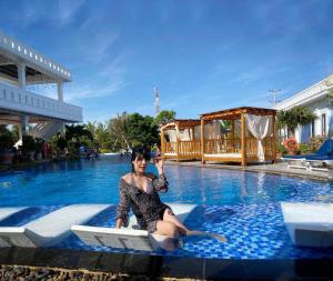 Eine Frau sitzt im Pool in der Unterkunft Fairy Hills Hotel in Mui Ne
