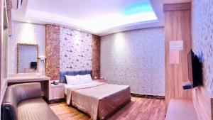um quarto de hotel com uma cama e um espelho em 楓情汽車旅館 em Pingtung City