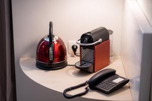 a table with a phone and a toaster and a toaster at Hotel Little Regina in Paris