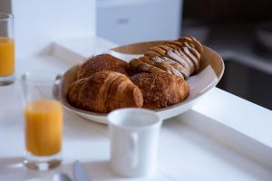 a plate of croissants on a table with a plate of pastries at Hotel Little Regina in Paris