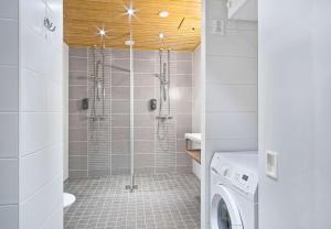a bathroom with a shower and a washer and dryer at Holiday Club Saariselkä Superior Apartments in Saariselka +53 photos
