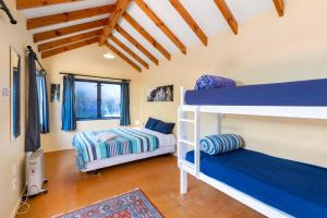 two bunk beds in a room with wooden ceilings at Raglan Backpackers in Raglan