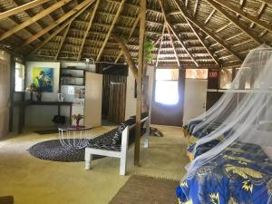 a room with a bed and a chair and a table at Moringa Ingadi in Treasure Beach