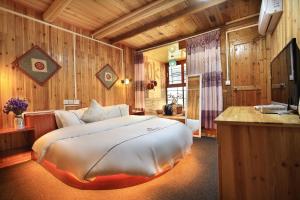 een slaapkamer met een groot bed in een kamer met houten wanden bij Longji Terrace La vie Inn in Longsheng