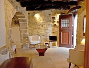 een woonkamer met een stenen muur en een deur bij Villa Cosmakis in Rodakino