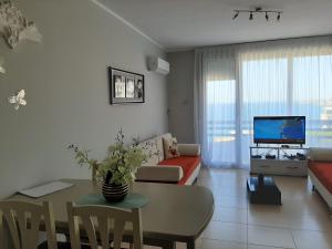 ein Wohnzimmer mit einem Sofa und einem Tisch in der Unterkunft Valentino apartments Bouganville Bay Saranda in Sarandë