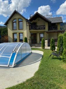 a house with a cover on the driveway at VIP House in Mykulychyn