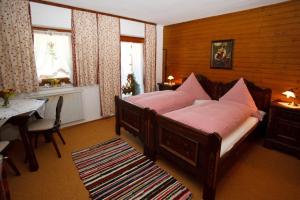 a bedroom with a bed with pink sheets and a table at Ferienhaus Hallweger in Ruhpolding