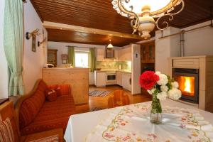 a kitchen and living room with a table with a vase of flowers at Ferienhaus Hallweger in Ruhpolding