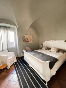 a bedroom with a large white bed and a window at Ti vengo a cercare Bed & Breakfast in Castellaro