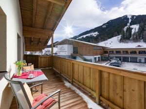 a balcony with a table and chairs and a snow covered mountain at Haus Chorblick in Westendorf