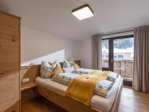 a bedroom with a bed and a large window at Haus Chorblick in Westendorf