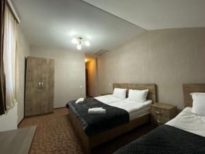 a hotel room with two beds and a window at Uptown Boutique Kazbegi in Kazbegi