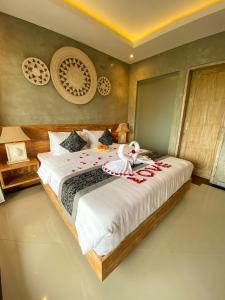 ein Schlafzimmer mit einem Bett mit einem ausgestopften Tier darauf in der Unterkunft Goutama Homestay in Ubud