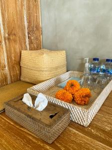 una mesa con dos cestas con flores naranjas y botellas de agua en Goutama Homestay, en Ubud