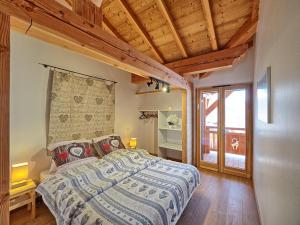 a bedroom with a bed in a room with wooden ceilings at Chalet Arpitan - les Carroz - Grand Massif in Les Carroz d'Araches