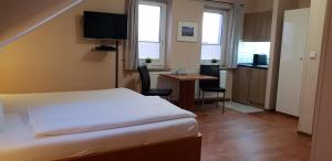 ein Hotelzimmer mit einem Bett und einem Tisch mit Stühlen in der Unterkunft Airport Hotel One Aparthotel Sylt in Tinnum