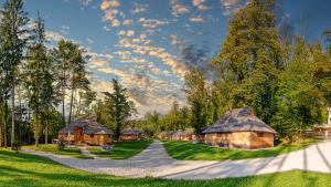 eine Reihe von Holzhütten auf einem Feld mit Bäumen in der Unterkunft Slovenia Eco resort in Stahovica
