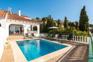 a swimming pool in the backyard of a house at Villa Carolina in Son Bou