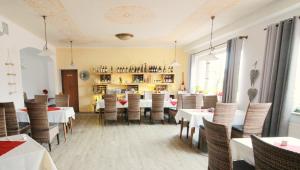 a dining room with white tables and chairs and a library at Hotel Zur Linde in Hechthausen