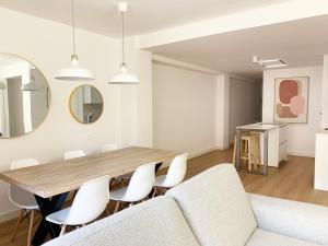 a dining room with a table and white chairs at Casa Condes de Gómara in Soria
