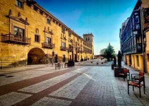 una calle urbana vacía con edificios y una torre del reloj en Casa Condes de Gómara, en Soria