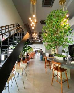 a lobby with a staircase and tables and chairs at Manatidur@THE HUB SS2 in Petaling Jaya