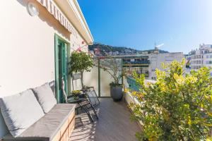 een balkon met een bank en een aantal planten in een gebouw bij La Terrasse du Port AP4212 in Nice