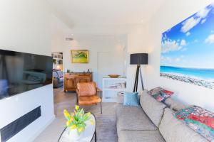 een woonkamer met een bank en een tv bij La Terrasse du Port AP4212 in Nice