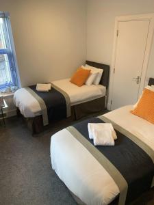 a room with two beds with orange and black at Muir Bank in Muir of Ord