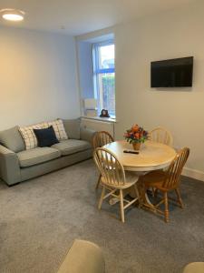 a living room with a couch and a table with chairs at Muir Bank in Muir of Ord