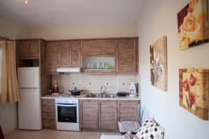 a kitchen with wooden cabinets and a white refrigerator at Deep Blue in Agios Nikitas