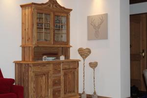 a wooden cabinet in a living room next to a wall at Landhaus Patricia in Ellmau