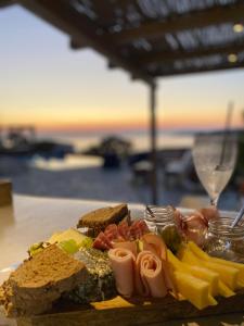 een bord eten op een tafel met brood en kaas bij Iris villa in Koundouros