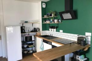a kitchen with green walls and a wooden counter top at Maison Chiche in Bain-de-Bretagne
