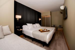 
a hotel room with a bed, table, and a lamp at Hotel Plaza in A Coruña
