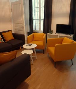 ein Wohnzimmer mit gelben Stühlen und einem Tisch in der Unterkunft LE 1 " GÎTES TOUT CONFORT à COLMAR CENTRE" in Colmar