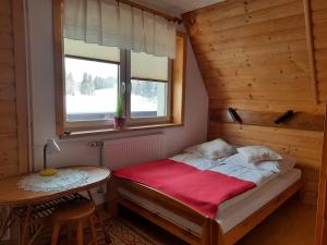 a small bedroom with a bed and a table at Pokoje u Teresy in Czarna Góra +100 photos
