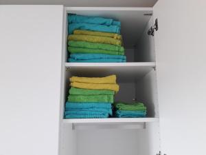 un armario con toallas coloridas en un estante en schöne 3 Zimmer Stadtwohnung en Eppelheim