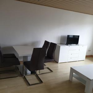 Habitación con mesa, 2 sillas y TV. en schöne 3 Zimmer Stadtwohnung en Eppelheim