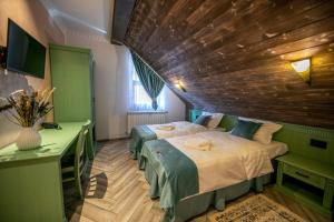 a bedroom with two beds and a wooden ceiling at Hanul Tentea-Pasul Gutai in Baia-Sprie