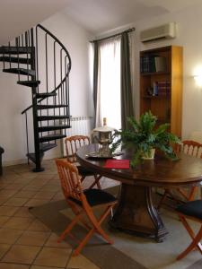 comedor con mesa y sillas y escalera de caracol en Residenza Monti, en Roma