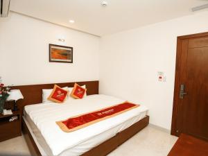 a bedroom with a bed with white sheets and red pillows at Hacom Galaxy Hotel in Phan Rang–Tháp Chàm +27 photos