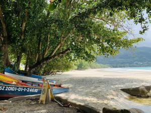 two boats sitting on the shore of a beach at Oceanic View Apartments in Beau Vallon