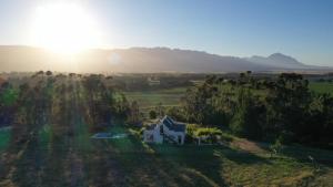 an aerial view of a house in a field with the sun setting at Raptor Rise in Tulbagh