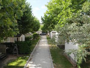 un chemin traversant une cour avec des maisons et des arbres dans l'établissement LE CASQUE ROI, à Salavas